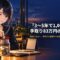 セーラー服姿の月城ミオがガラス瓶に硬貨を入れ、机には卓上カレンダーと電卓が置かれている
